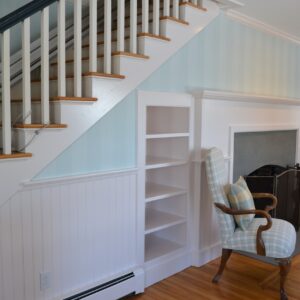 Stairs finished in white paint and walls in sea foam wallpaper.